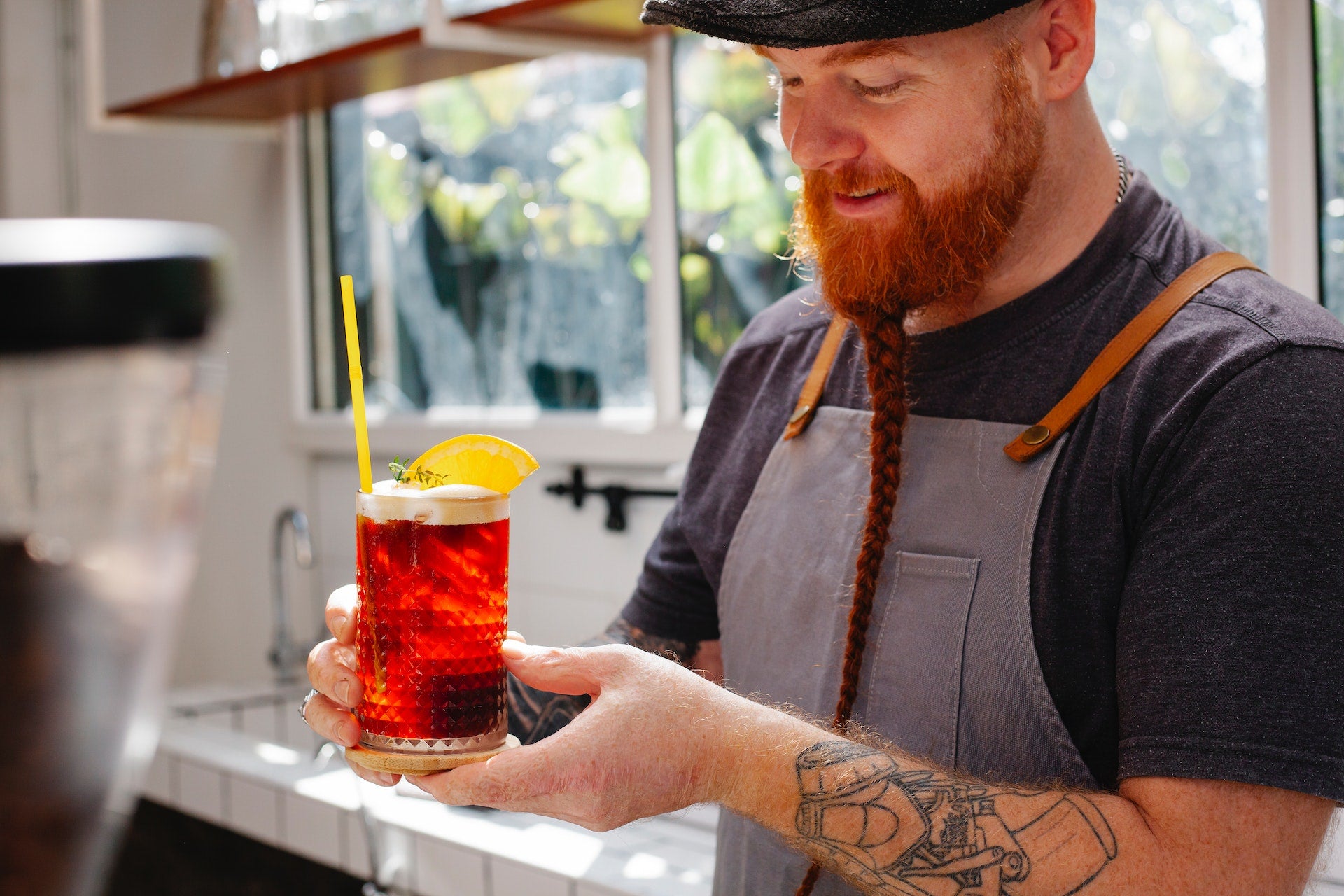 smiling bartender with glass of fruit cocktail