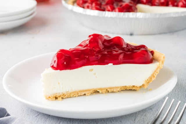 A slice of cheesecake with a cherry topping